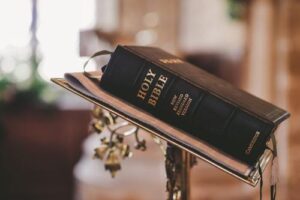 a-black-bound-copy-of-the-bible-on-a-stand-adorned-with-golden-vines-m.jpg