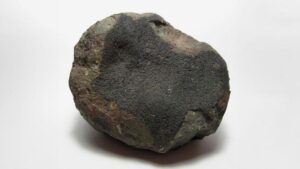 Un esemplare di mezzo chilo circa del meteorite largo circa 8 centimetri. Parte di esso è coperta da chiazze di crosta di fusione nera opaca. Sono visibili diverse strutture incastonate nella matrice grigia sottostante