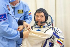 Il cosmonauta russo Oleg Kononenko indossa la sua tuta russa Sokol mentre viene chiuso con la zip dai tecnici al Cosmodromo di Baikonur