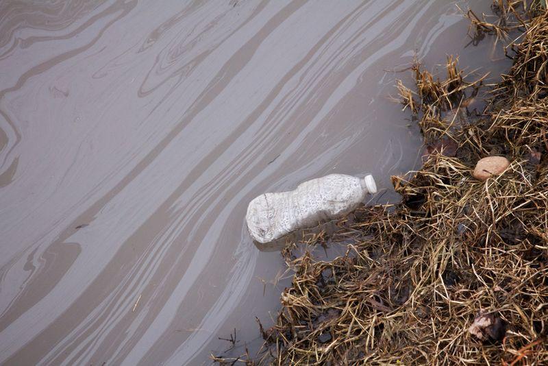 PFOA e una bottiglia d'acqua che giace in un letto d'acqua.