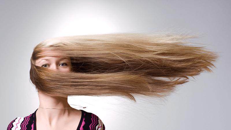 Una donna con i capelli che vanno di lato, piuttosto che con la gravità.