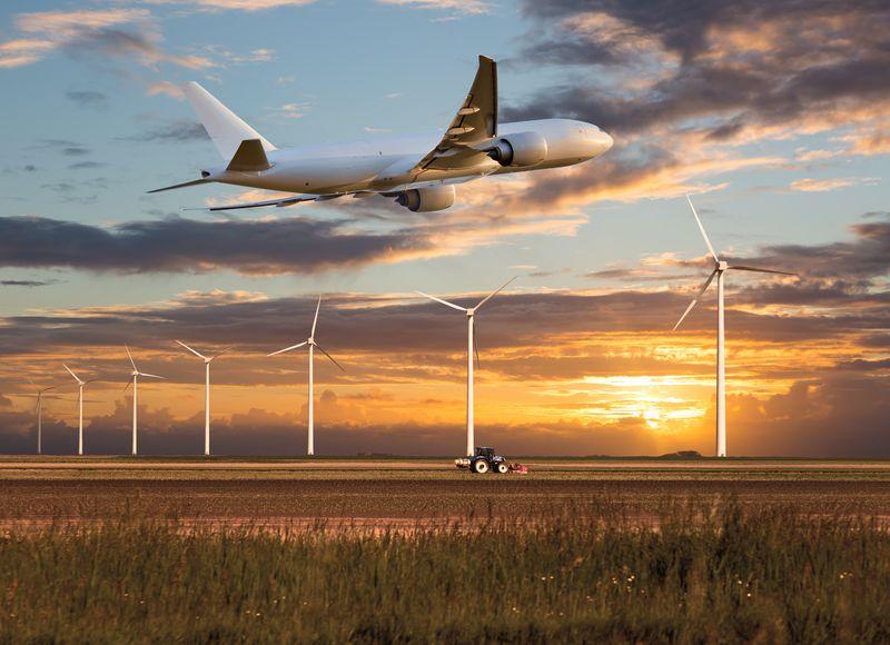 plane-takes-off-above-a-farm-field-and-wind-electric-generators-m-1.jpg