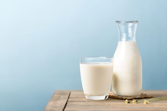 a-carafe-and-a-glass-of-milk-on-a-wooden-table-in-front-of-a-blue-wall-m-1.jpg