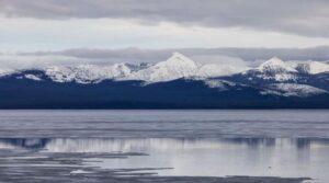 Yellowstone Lake ghiacciato con montagne coperte di neve sullo sfondo