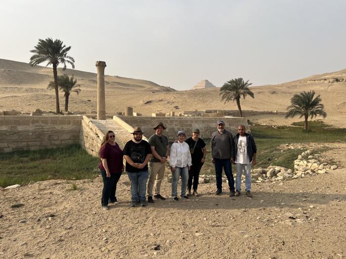 Il team di ricerca si trova di fronte alla piramide del Tempio della Valle di Unas, che fungeva da porto fluviale nell'antichità.