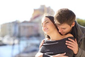 man-standing-behind-a-woman-who-has-her-eyes-closed-he-is-holding-her-shoulders-and-sniffing-her-neck-m.jpg