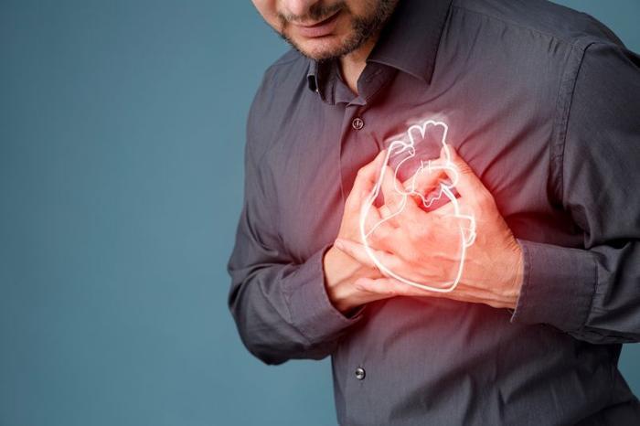 bearded-person-clutching-their-chest-with-both-hands-a-glowing-illustration-of-an-anatomical-heart-superimposed-over-their-hands-m-1.jpg