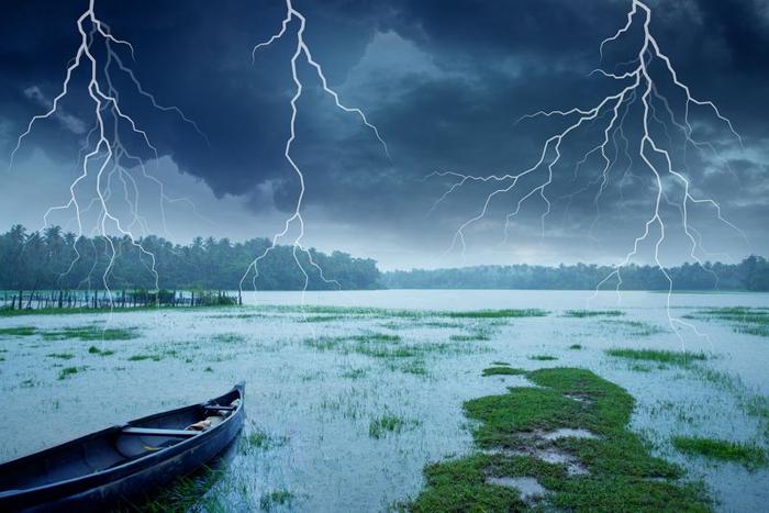 Bagliori di fulmini in una tempesta che colpiscono un lago deserto con una barca di legno a bordo