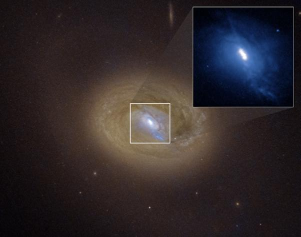 Immagine di Hubble di MCG-03-34-064 con il centro espanso. Tre punti luminosi sono visibili osservando da vicino, due dei quali hanno le emissioni di raggi X indicative di buchi neri. Il terzo è probabilmente una chiazza di gas.