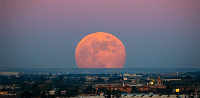 La luna sembra particolarmente grande (e rossa) sullo sfondo di una città spagnola nel giugno 2020.