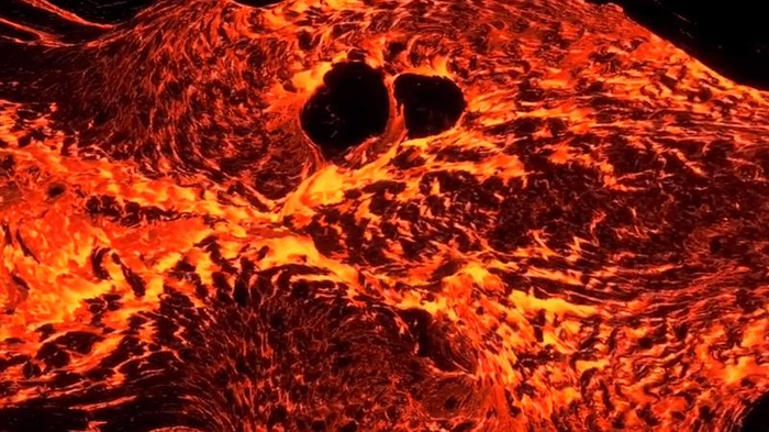 Rosso arancione e giallo primo piano del flusso di lava con due piccole rocce che si stanno sciogliendo.