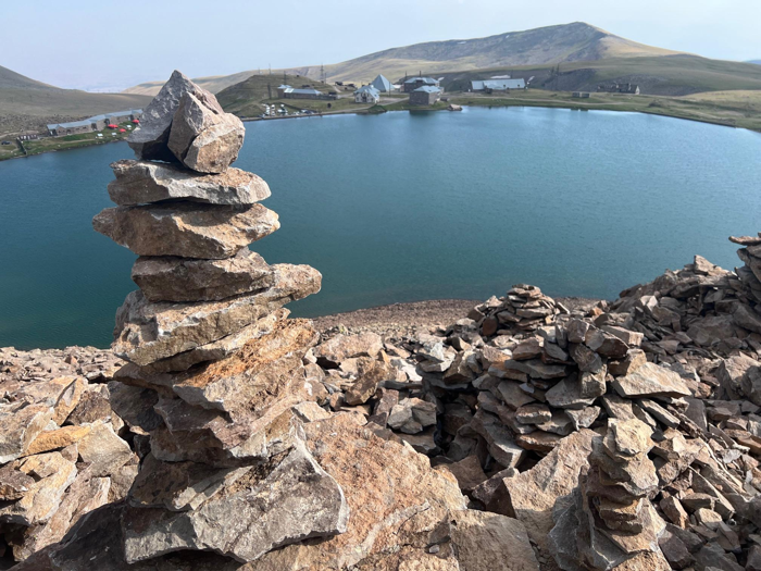 Ci potrebbero dire di non costruire mucchi di rocce, ma forse in una stazione di ricerca che studia i fulmini è diverso. Il lago Kari, sfortunatamente chiamato, in secondo piano e il Centro Ambientale Spaziale sul Monte Aragats in lontananza