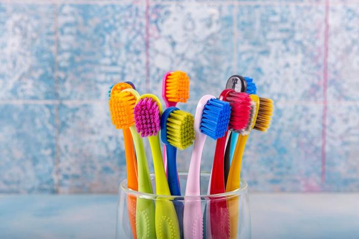 colourful-toothbrushes-in-a-glass-container-in-a-bathroom-m.jpg