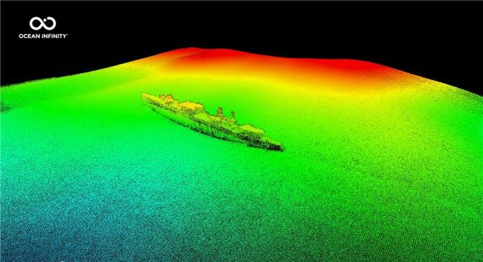 L'immagine mostra la scansione multibeam della nave che riposa sul fondo del mare. L'immagine mostra il fondale marino in tonalità di verde che diventano gialle e poi rosse man mano che l'elevazione aumenta. La nave si trova al centro di una grande macchia verde e appare intera. 