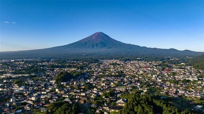 Il Monte Fuji iconico del Giappone, fotografato senza neve in estate, domina la città di Fujikawaguchiko.