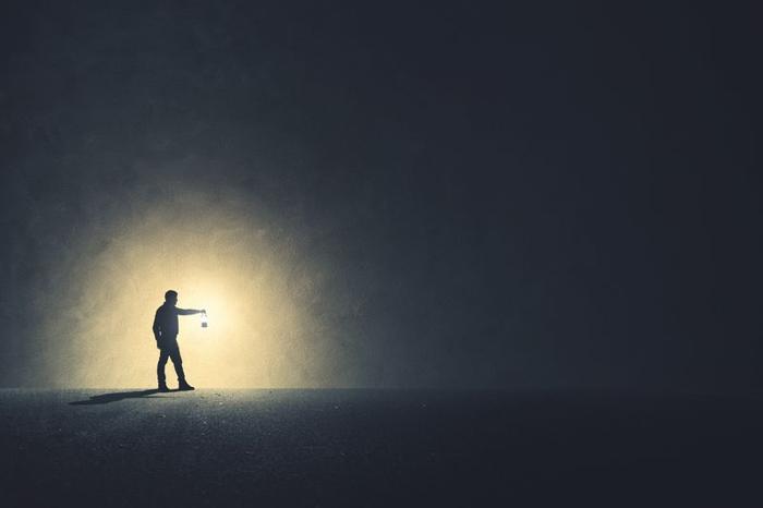 man-walking-in-the-dark-with-lamp-illuminating-his-path-m.jpg