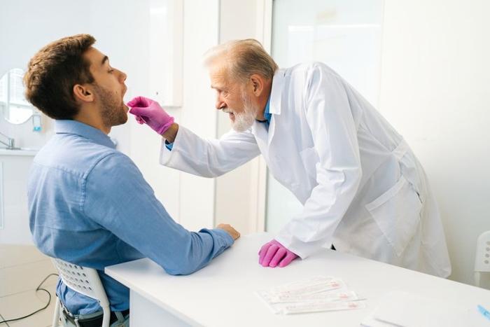 Un uomo riceve uno scambio di bocca dal suo medico.