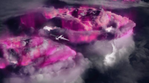 un aereo è visto sopra la tempesta. la tempesta brilla di rosa come modo per mostrare da dove provengono i raggi gamma.