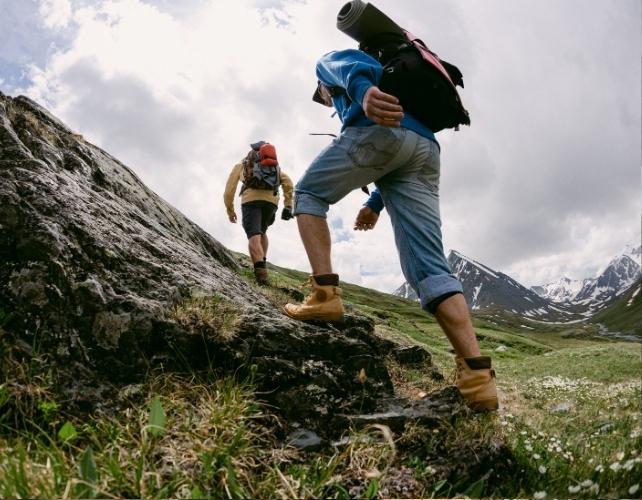 Persone che trasportano attrezzature su per una collina