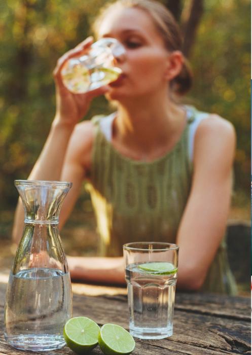 Persona che beve acqua nella natura