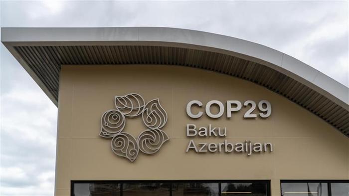 Cop29 logo and signage on the information center building. The text says COP29 Baku Azerbaijan and the logo is a five-petal flower