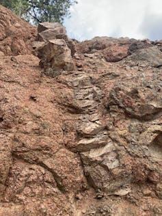 Un lato di scogliera che mostra una lunga striscia di Tava di colore più chiaro che taglia il granito Pikes Peak. L'injectite qui è alta 5 metri