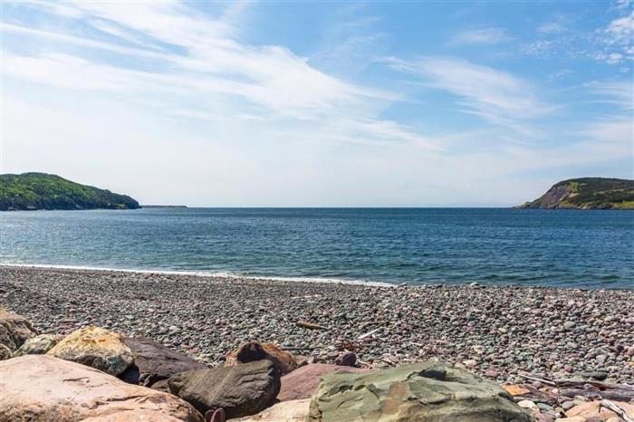 rocky-beach-with-blue-sky-and-green-land-masses-in-the-background-m.jpg