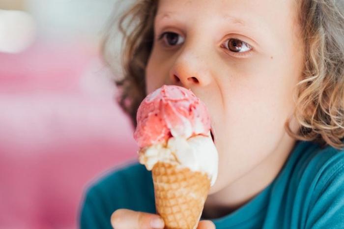 Bambino che mangia un cono gelato