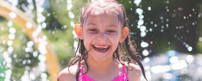 Un bambino sorridente con acqua che schizza intorno a lui