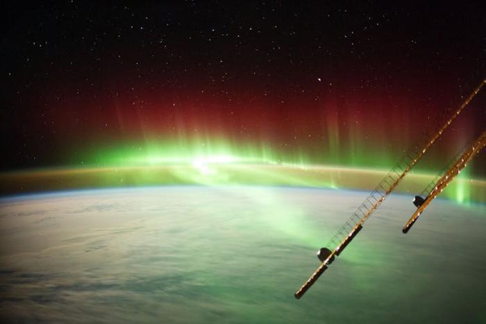 Nastri di luce verde luminosa che si arricciano attraverso l'atmosfera terrestre.