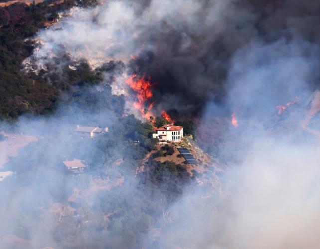 Una casa in fiamme con molto vento