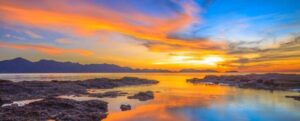 Mare e cielo macchiati di arancione tra il blu al tramonto